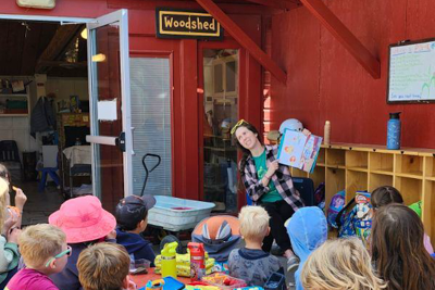Brenna reading aloud to a group of young students